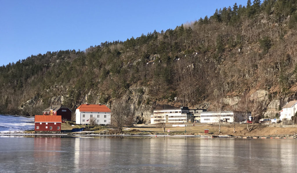 Landskapsbilde som viser Letti AS inntil en fjellside med en fjord i forgrunnen